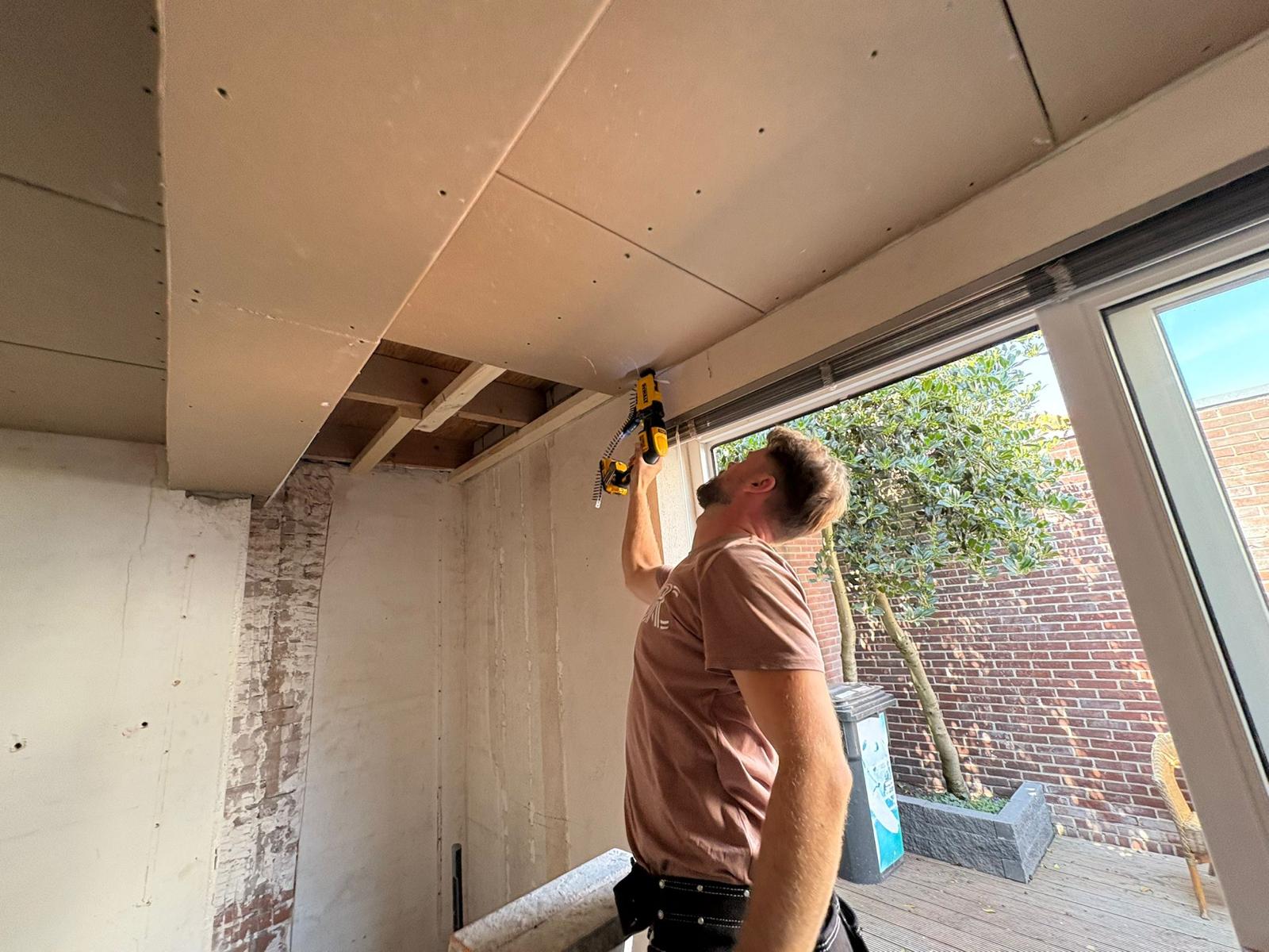 Timmerman aan het werk aan verlaagd plafond